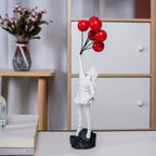 Beeldhouwwerk van een meisje met een ballon in Banksy-stijl voor tafeldecoratie en creatieve woonkamerdecoratie